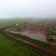 Aerial Flying Out View on Oil Pumps at Oilfield Cluster in a Foggy Field After Rain - VideoHive Item for Sale