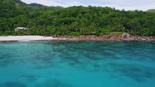 Aerial Fly Towards Exotic Tropical Jungle Beach with Coral Reef and Blue Bay at Mahe Island