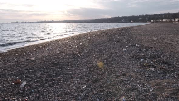 Environmental pollution on the beach near railway. Spilled garbage on the beach of the big city