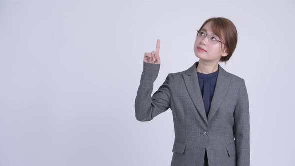 Young Happy Asian Businesswoman Thinking and Pointing Up