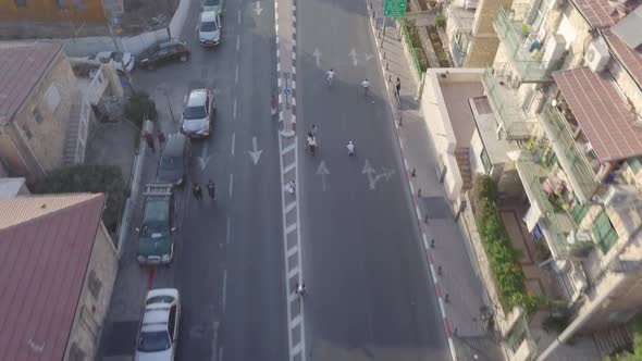 Aerial clip of children racing downhill in the streets of Jerusalem Israel