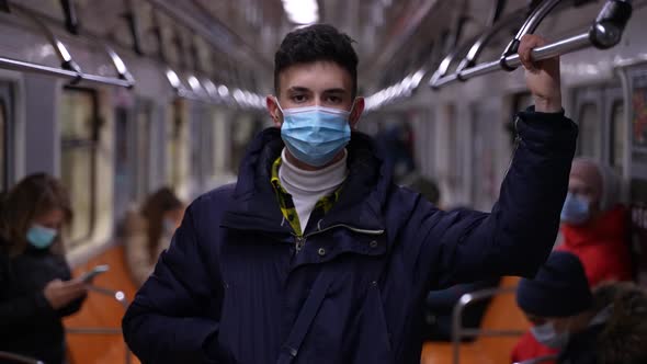 Teenager in Face Mask and Jacket Riding in Subway