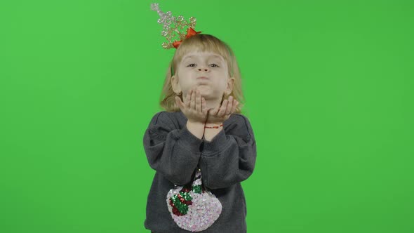 Happy Beautiful Little Girl in a Sweater with a Snowman