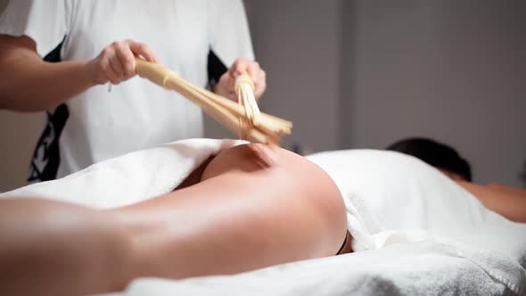 Woman massage therapist makes powerful anti-cellulite massage buttocks working tool a female client