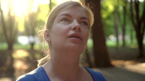 A Woman Removes a Medical Mask in a Park