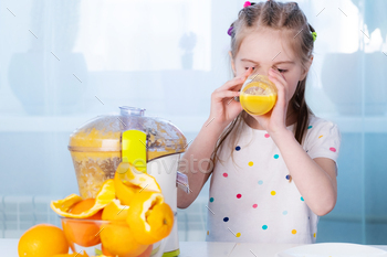 Little girl trying fresh orange juice