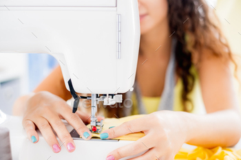 Female hands on sewing machine