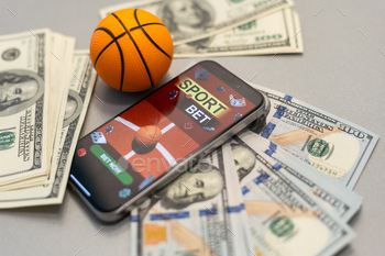 Sports betting website in a mobile phone screen, ball, money