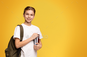 Young Boy Holding Book and Backpack