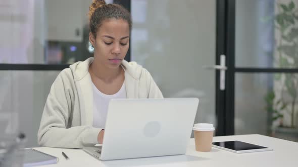 African Woman Shaking Head As No Sign While Using Laptop in Office
