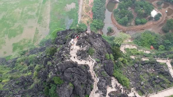 Aerial from the top of Vietnamese dragon temple on top of large limestone karst. Hang Mua, Tam Coc,