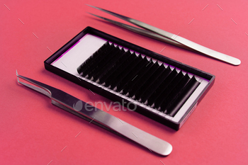 Professional eyelash extension tools on red background