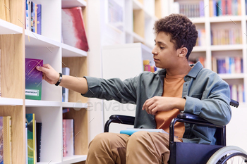 Boy with Disability with Disability in Library and Choosing Books