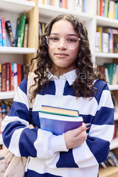 Girl Wearing Glasses and Holding Books in Library