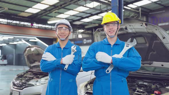 Portrait of Asian two handsome automotive mechanic men stand in garage.