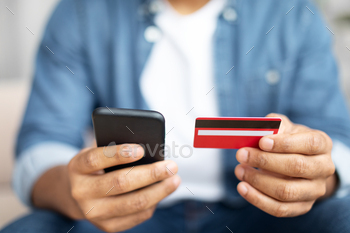 Man Holding Credit Card and Cell Phone, Cropped