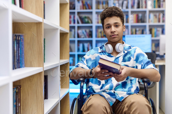 Boy with disability using wheelchair in library