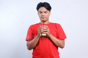 Relaxed Asian Young Male Holding Juice Drink