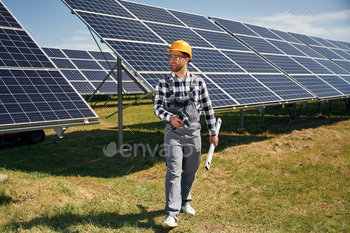 Ready to work, with drill. Engineer with photovoltaic solar panels outdoors at daytime
