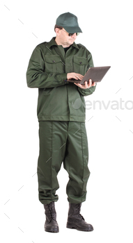 Man in workwear stands with notebook.