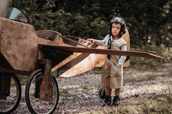 A young boy aviator on a homemade airplane in a natural landscape Authentic mood of the picture.