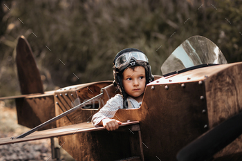 A young boy aviator in a homemade airplane in a natural landscape Authentic mood of the picture.