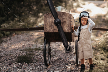 A young boy aviator on a homemade airplane in a natural landscape Authentic mood of the picture.
