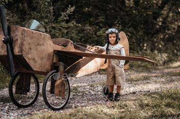 A young boy aviator on a homemade airplane in a natural landscape Authentic mood of the picture