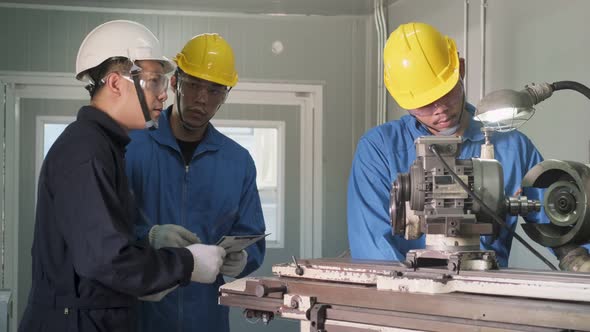 Mechanical technicians wearing protective glasses and helmet, operate machine for safety precaution.