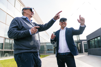Businessmen Engaging with Virtual Reality Glasses Outside Modern Office