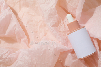 Cosmetic oil in a bottle on a pink background