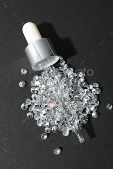 A cosmetic dropper with a bunch of diamonds