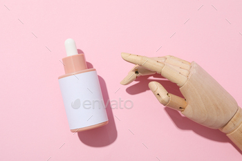 A cosmetic bottle in a mannequin's wooden hand