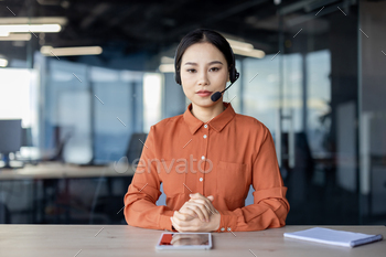 Professional woman in headset engaging in serious business video call