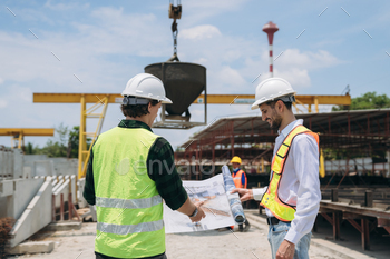 Engineers discussing building plans at a construction site.