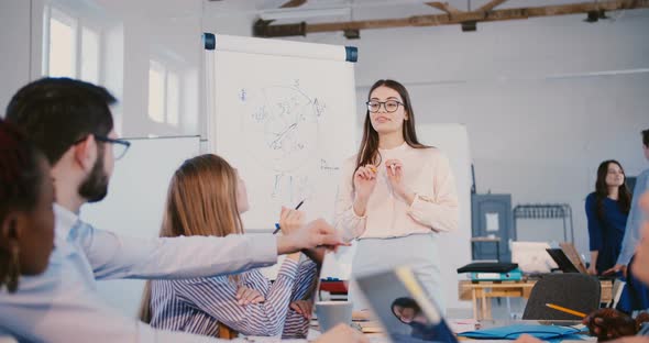 Young Professional Female Law Firm Expert in Glasses Sharing Experience with Multiethnic Office