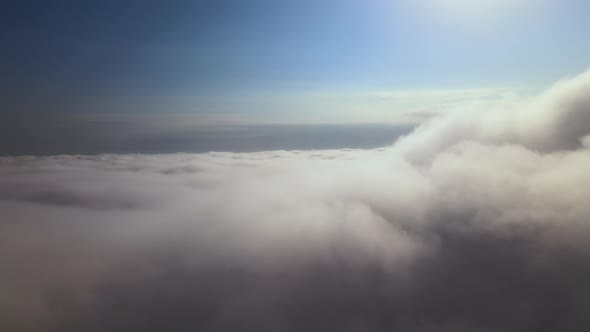 Aerial View From Airplane Window at High Altitude of Earth Covered with Puffy Cumulus Clouds Forming