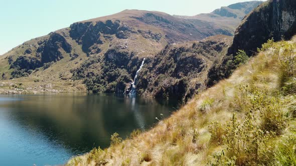 4k daytime video looking over a beautiful deep blue lake and a high waterfall at the 5 Lakes of Pich
