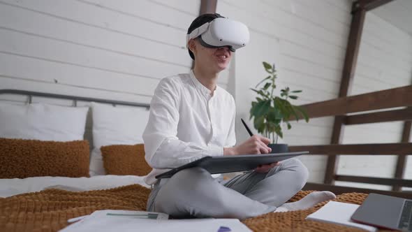 Side Angle View of Positive Talented Creative Asian Designer in VR Headset Drawing Sketch on