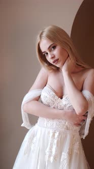 Young Blonde Woman in Elegant White Dress Posein Studio