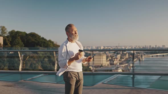 Elderly Man Enjoys Riding Electric Unicycle Holding Coffee