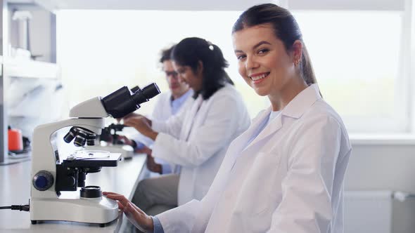 Scientist with Microscope Working in Laboratory