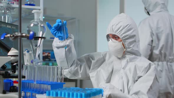 Technician Ppe Suit Doing Experiment Checking Test Tube