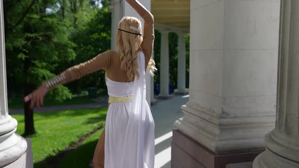 a Blonde in a Greek Chiton is Dancing Among the Columns