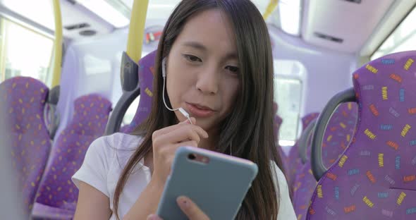 Woman use of mobile phone on bus in Hong Kong city