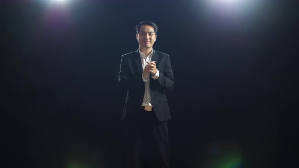 Smiling Asian Speaker Man In Business Suit Clapping His Hands While Standing