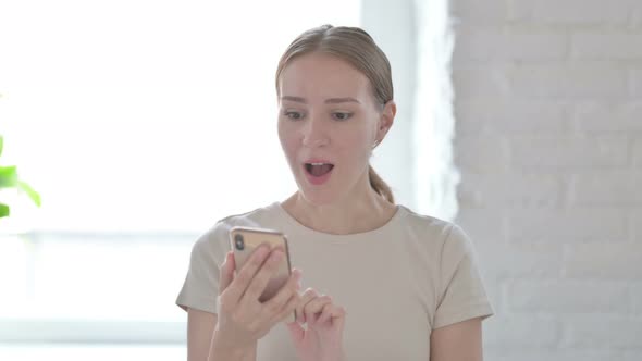 Excited Woman Celebrating Win on Smartphone