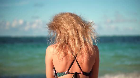 Girl In Bikini Sitting On Sand. Sexy Young Blonde Travel Girl Relaxing On Caribbean Beach.