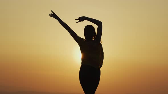 Happy woman dancing at sunset