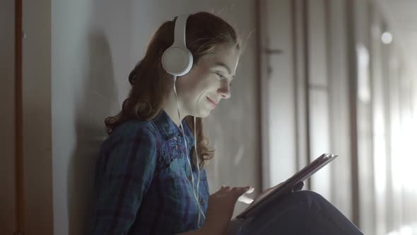 Female Student with Tablet Sitting on Floor